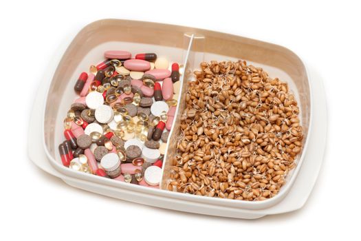 Container with pill, tablet and wheat on white background