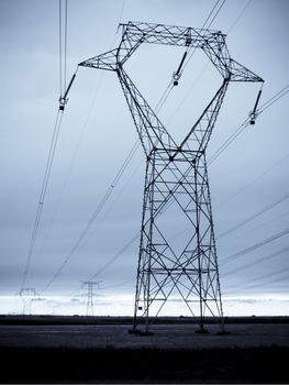 A long line of electrical transmission towers carrying high voltage lines.