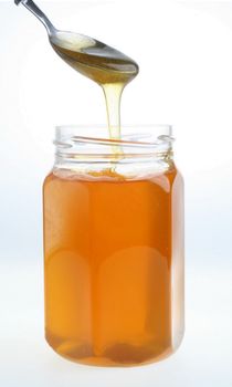 A photo of a single jar of honey on a white background