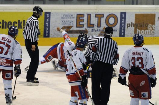 ZELL AM SEE, AUSTRIA - NOVEMBER 30: Austrian National League. Referee and Graz players watching players fighting. Game EK Zell am See vs. ATSE Graz (Result 0-4) on November 30, 2010, at hockey rink of Zell am See