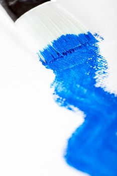 Art paint brush and blue acrylic paint.