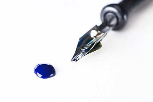 Drop of blue ink and calligraphy pen.