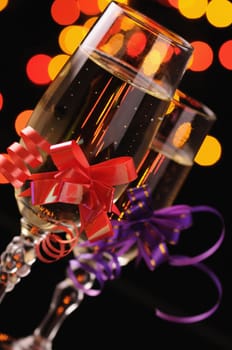 two wineglasses with a champagne on a background of multicoloured sparks