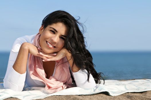 Portrait of beautiful smiling native american girl laying at beach