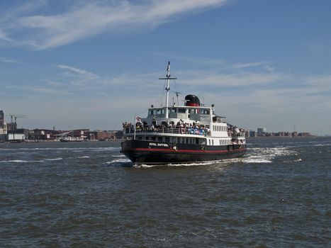 Laden with sightseers a ferry makes its way across the Mersey