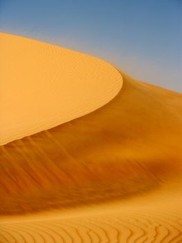 Wind blowing on a dune in the Rub al Khali or Empty Quarter. Straddling Oman, Saudi Arabia, the UAE and Yemen, this is the largest sand desert in the world.