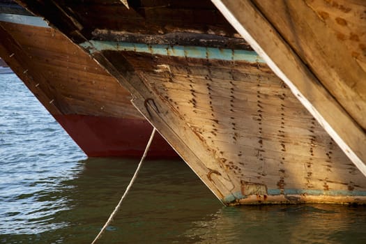 The bows of traditional wooden trading dhows moored in Dubai Creek, UAE.