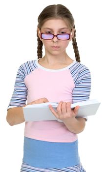 Serious schoolgirl with spectacles and book on a white background