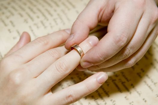 The man's hand dresses a ring on a female finger taken as close up 