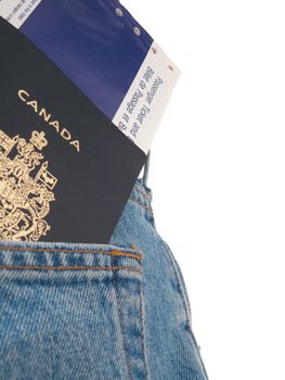 A passport and airline ticket in a back pocket of someone wearing jeans, shot from behind, with back pocket visible, isolated on white.