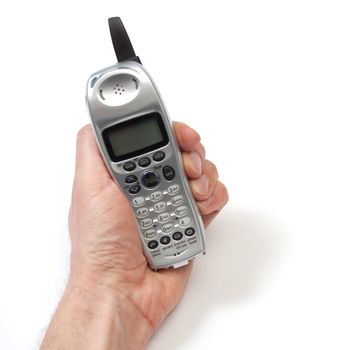 A hand holding a cordless phone, with the display facing the camera.