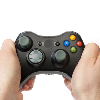 Hands holding a wireless gaming controller, isolated on white.