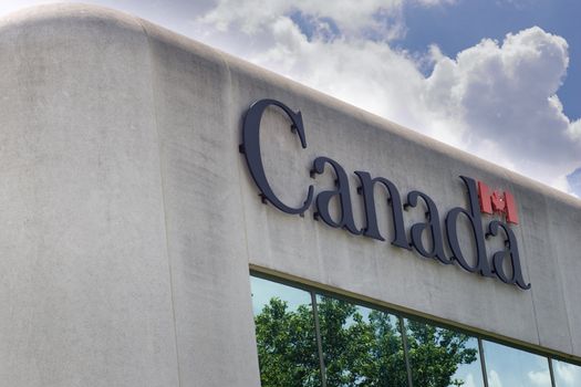 The corner of a Canadian government office building, with Government of Canada logo as the prominent focus of the image.