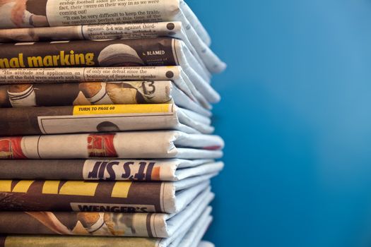 A stack of newspapers with a blue background
