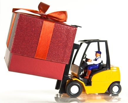 A toy forklift truck delivering a red present