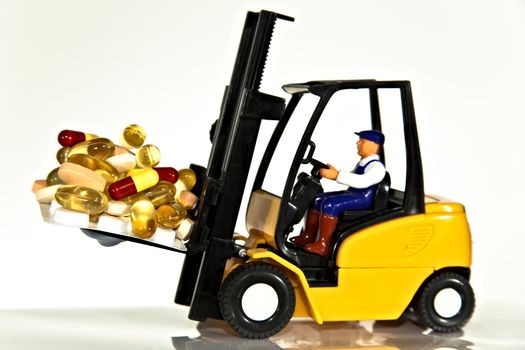 A toy fork lift truck lifting a pallet full of drugs or tablets