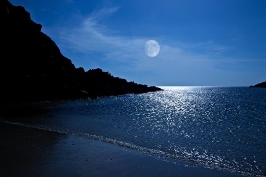 The rising moon reflected in the ocean from a beautiful bay
