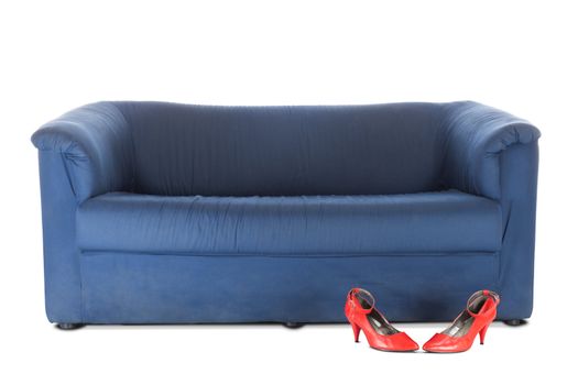 Blue textile couch and red female shoes. Conceptual photo. Isolated over white