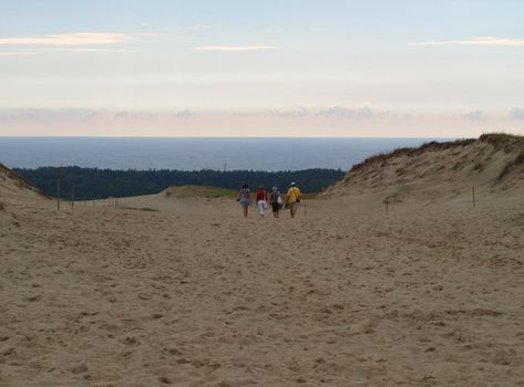 Group of people walking in the dunes near the Baltic sea