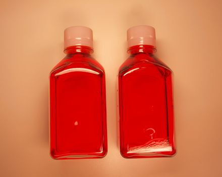 Flasks with a red liquid cell growth medium used in laboratory research