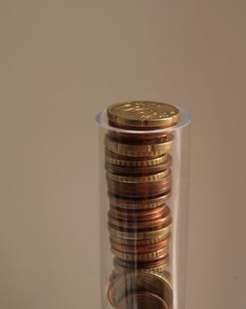Euro coins forming a column in a trasparent tube