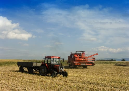 Big red combine performing his job