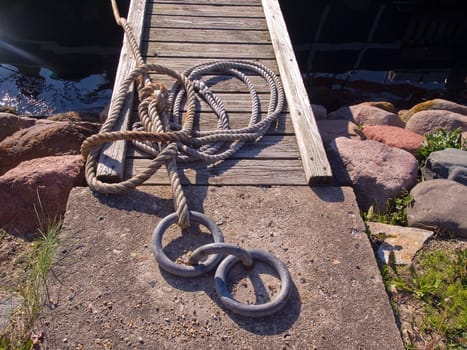 Classical anchoring point made of cast iron in a port marina / nautical background horizontal image