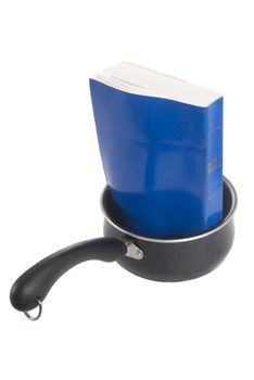 Paperback Bible in Sauce Pan, Isolated on a white background.