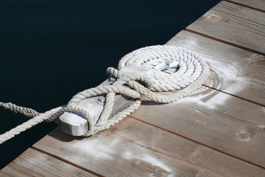 Boat rope secured to cleat on the dock