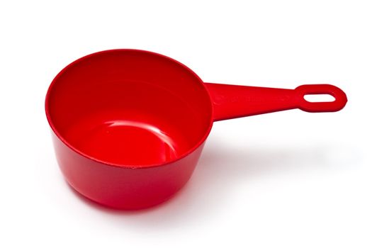 Red plastic measuring cup isolated on white background 
