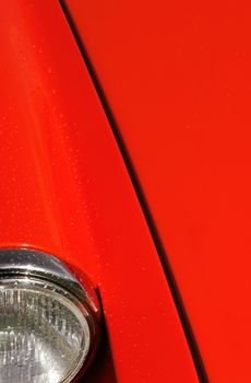 red sports car hood with some raindrops on panels