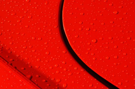 background of raindrops on a red sports car panel