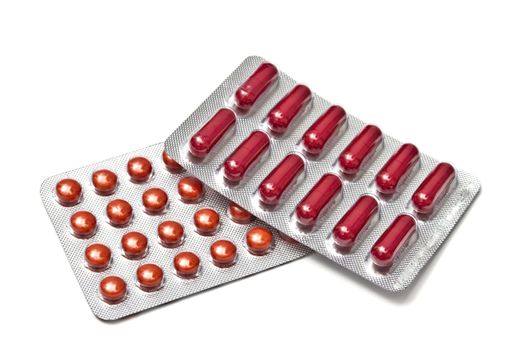 Red pills and capsules isolated on white background
