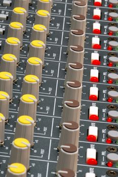 dials and led lights on a soundboard mixer