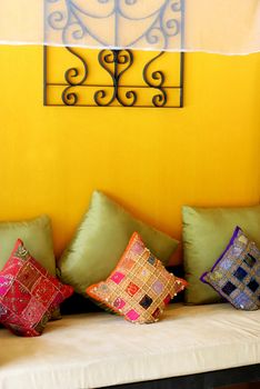 Bright sofa covered with ethnic pillows - home interiors.