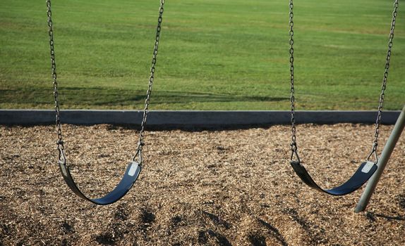 Two swings with grass background