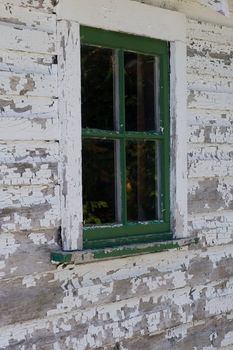 A green window surrounded by a weathered white