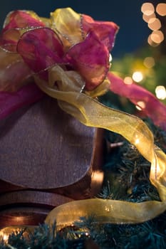 Closeup of various colors of ribbon and garland, as they decorate the end of a banister.