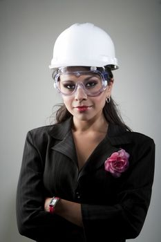 Handsome young woman in hard hat and safety goggles