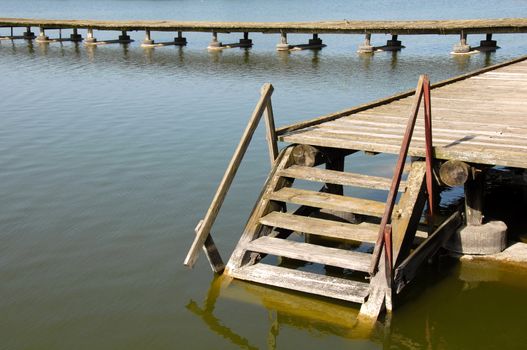 old wooden stairs on yellowish lake at Palic, Serbia