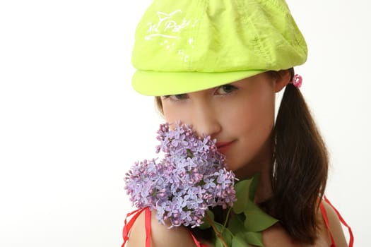 The girl in a green cap with a lilac bouquet