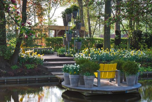 Modern garden at the waterside  in spring in colors white, grey and yellow 