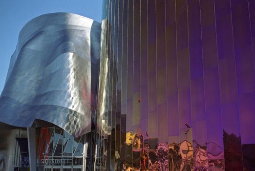 Fairground rides reflected in the 'purple haze' of the Experience Music Project built in honour of Jimi Hendrix by Paul Allen co-founder of Microsoft, designed by Frank Gehry