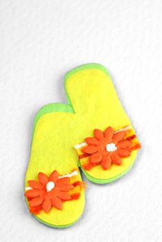 miniture felt beach flip-flops on off-white background 