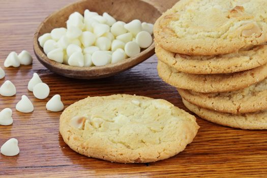 Macadamia Nut Cookies with a wooden spoon full of white chocolate chips.