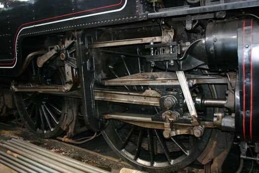 detail of the wheels and pistons of a steam train