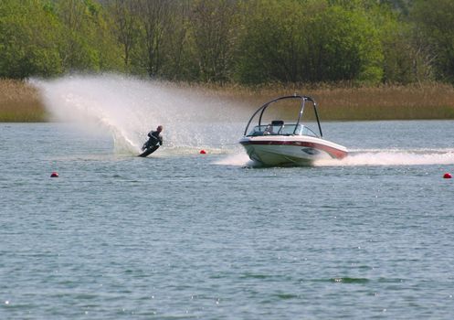 water skier being towed behind a motor boat on a lake