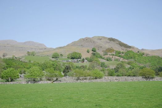 rural scene of hills and stone walls against a blue sky