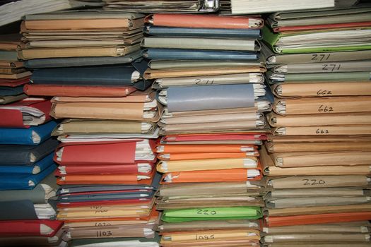 Multicolored cardboard files containing loads of paperwork