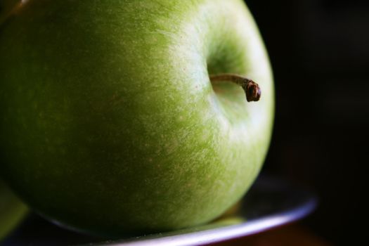 green apple take with natural light and a dark background